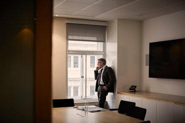 Geschäftsmann im Büro, der mit seinem Smartphone telefoniert - CUF44008