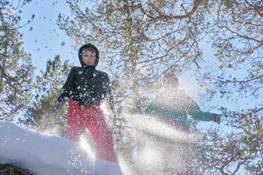 Two boys jumping in snow, low angle view - CUF44056