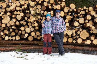Porträt von Vater und Sohn, vor einem Stapel Holzscheite - CUF44058