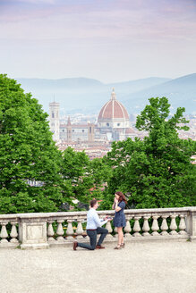 Junger Mann macht einer Frau einen Heiratsantrag, Santa Maria del Fiore im Hintergrund, Florenz, Toskana, Italien - CUF44086