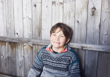 Boy outside wooden hut, portrait - CUF44116