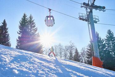 Kinderskifahrer unter der Seilbahn, Lauenen, Wallis, Schweiz - CUF44123