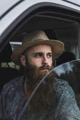 Bearded young man looking out of car window - KKAF02388