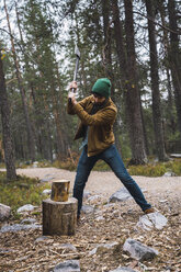 Man chopping wood in rural landscape - KKAF02394