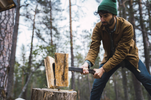 Man chopping wood in rural landscape - KKAF02396