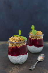 Two glasses of chia pudding with coconut milk, red fruit jelly and peanut granola topping - JUNF01358