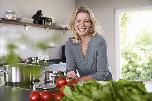 Portrait of happy woman cooking in kitchen - PDF01730