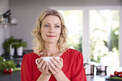 Portrait of woman drinking coffee in kitchen - PDF01746