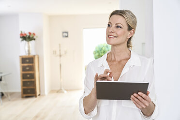 Smiling woman using tablet at home - PDF01764