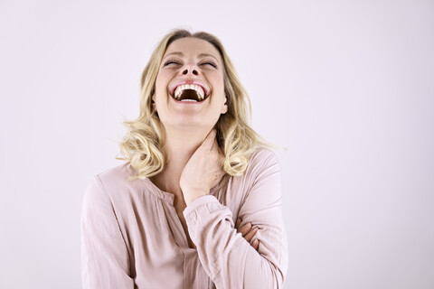 Portrait of laughing blond woman leaning back stock photo