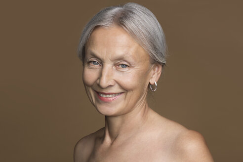 Porträt einer nackten älteren Frau mit grauem Haar vor einem braunen Hintergrund - VGF00008