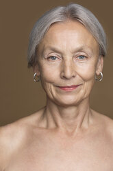 Portrait of naked senior woman with grey hair in front of brown background - VGF00009