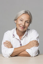 Porträt einer älteren Frau mit grauem Haar, die am Tisch sitzt - VGF00013