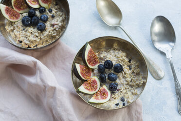 Bowls of porridge with sliced figs, blueberries and dried berries - JUNF01384