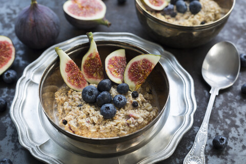 Schüssel Porridge mit geschnittener Feige, Heidelbeeren und getrockneten Beeren, lizenzfreies Stockfoto