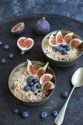 Bowls of porridge with sliced figs, blueberries and dried berries - JUNF01391