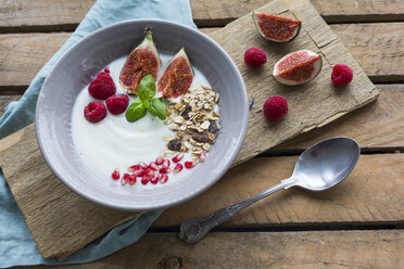 Bowl of natural yoghurt with fruit muesli, raspberries, figs and pomegranate seed - JUNF01428