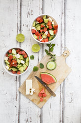 Wassermelonensalat mit Feta, Gurke, Minze und Limettendressing auf weißem Holz - LVF07448