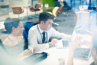 Businessman and woman sitting in airport lounge, using laptop - CUF44216