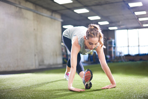 Frau macht Dehnungsübungen im Fitnessstudio, lizenzfreies Stockfoto