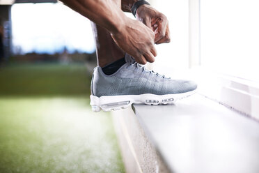 Man tying shoelace in gym - CUF44261