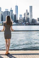 USA, New York, Brooklyn, back view of woman standing in front of East River - GIOF04552