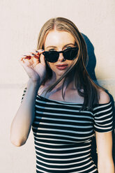 Portrait of woman wearing striped dress and sunglasses - GIOF04591