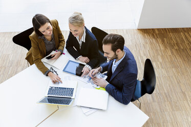 Colleagues in meeting using digital tablet and laptop - CUF44298