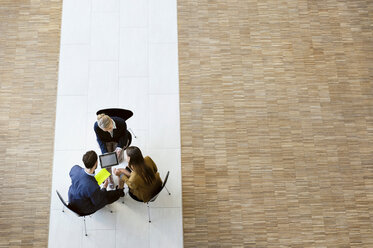 Colleagues chatting using digital, high angle view - CUF44299