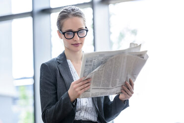 Geschäftsfrau liest Zeitung im Büro - CUF44337