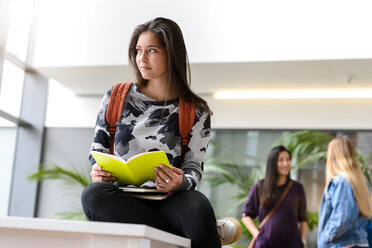 Junge Studentin liest ein Buch im Foyer der Universität - CUF44350