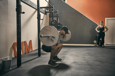 Man in gym weightlifting using barbell - CUF44368