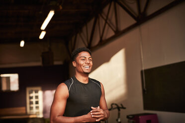Porträt eines Mannes im Fitnessstudio, der lächelnd wegschaut - CUF44374