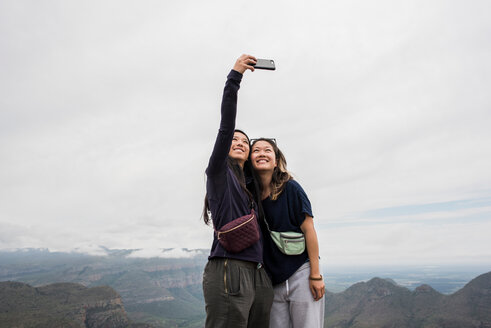 Zwei junge Touristinnen machen ein Selfie von den Drei Rondavels, Mpumalanga, Südafrika - CUF44392