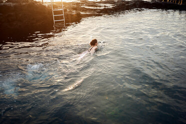 Frau schwimmt im Küstenpool bei Sonnenuntergang, Las Palmas, Gran Canaria, Kanarische Inseln, Spanien - CUF44419