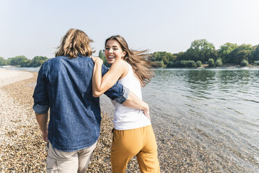 Glückliches, verliebtes junges Paar beim Spaziergang am Flussufer - UUF15377