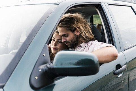 Affectionate young couple in a car stock photo