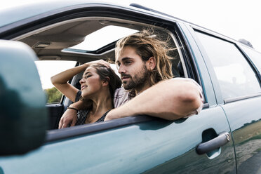 Glückliches junges Paar in einem Auto - UUF15428