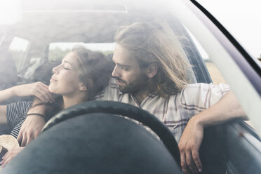 Zärtliches junges Paar in einem Auto - UUF15432