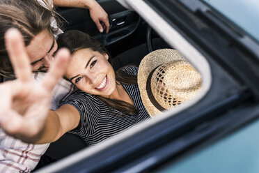 Glückliches junges Paar in einem Auto durch das Schiebedach gesehen - UUF15435