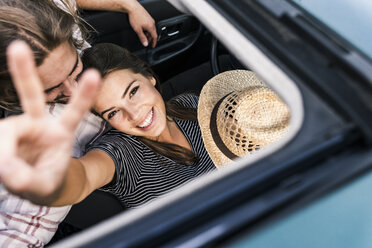 Happy young couple in a car seen through sunroof - UUF15435