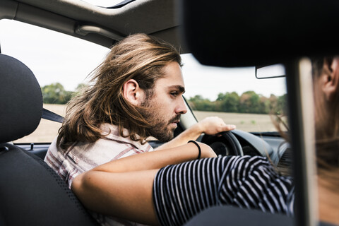 Young man looking at woman in a car stock photo