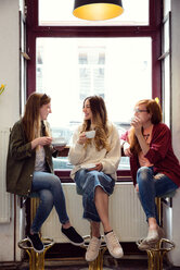 Junge Frauen unterhalten sich bei einem Kaffee im Café - CUF44522