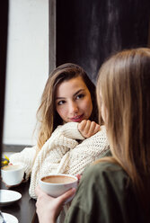 Junge Frauen unterhalten sich bei einem Kaffee im Café - CUF44524