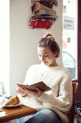 Woman using digital tablet in cafe - CUF44530