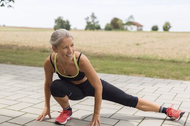 Mature woman doing workout in the countryside in summer - JUNF01454