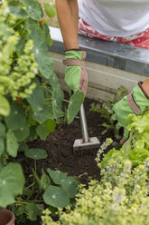 Nahaufnahme einer Frau bei der Gartenarbeit im Hochbeet - JUNF01466