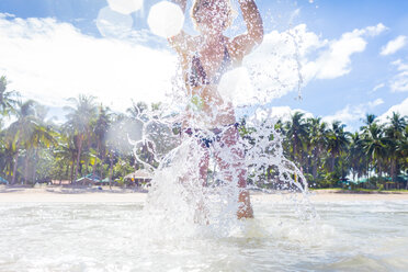 Woman splashing in sea, low angle view, Nacpan Beach, Palawan, Philippines - CUF44567
