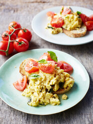 Scrambled eggs with tomatoes, on bread, close-up - CUF44572