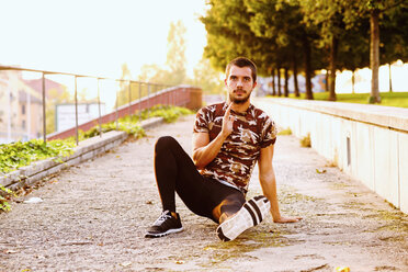 Young man exercising outdoors, stretching - CUF44742